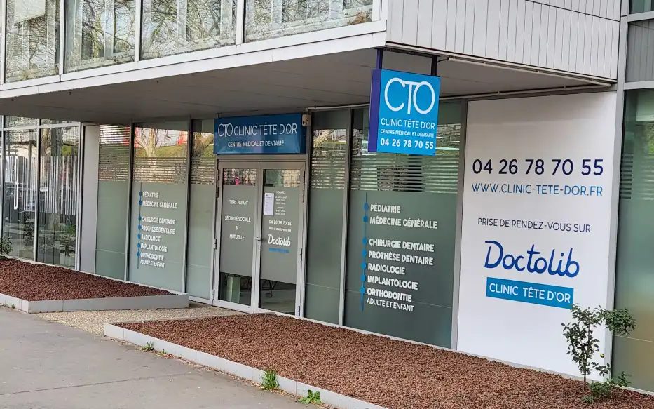 La façade vitrée du centre, avec l'enseigne Clinic Tête d'Or au-dessus de l'entrée